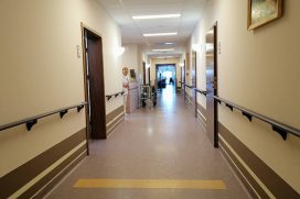 szpitalny korytarz z dzwiami do wejść na sale dla pacjentów